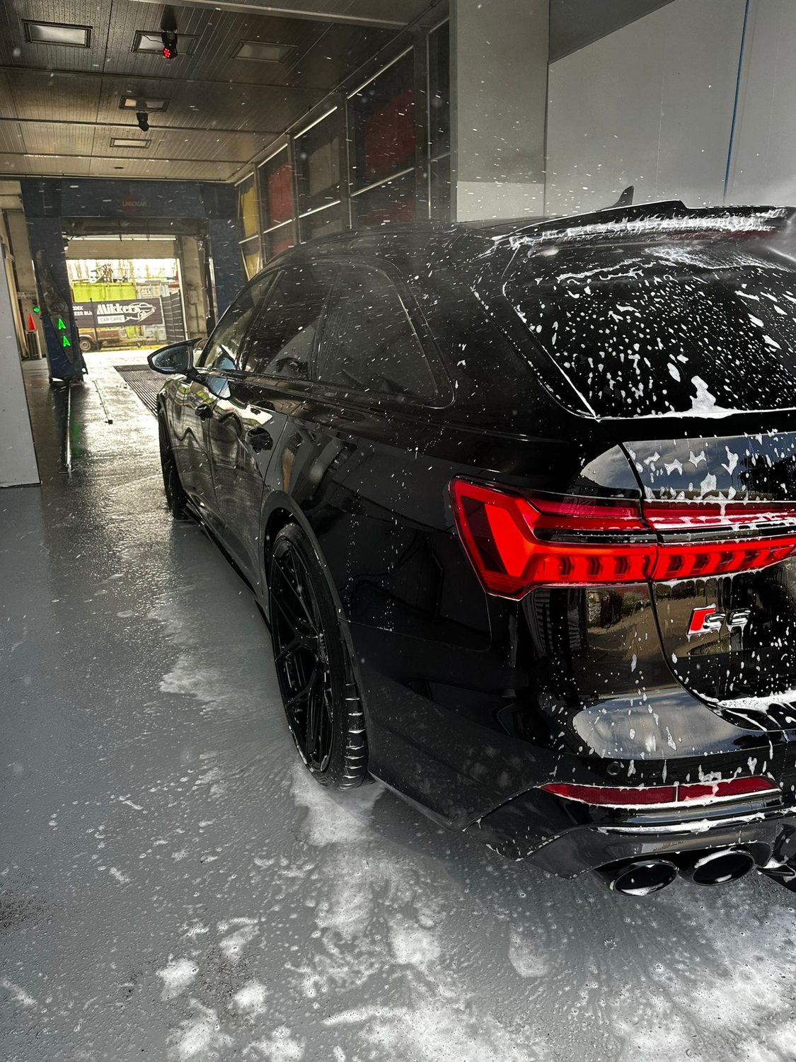 Zwarte Audi RS6 wordt met de hand ingeschuimd in de wasstraat van Mikkers Car Care